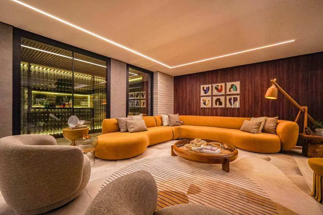 Sala de convívio com sofá curvo e adega climatizada